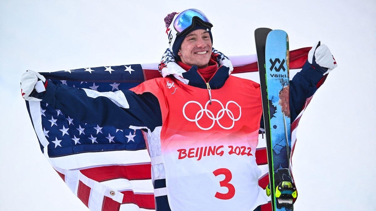 Bronze medallist USA's Alex Ferreira poses with his national flag on the podium during a venue ceremony after the freestyle skiing men's freeski halfpipe final run during the Beijing 2022 Winter Olympic Games at the Genting Snow Park H&S Stadium in Zhangjiakou on February 19, 2022.