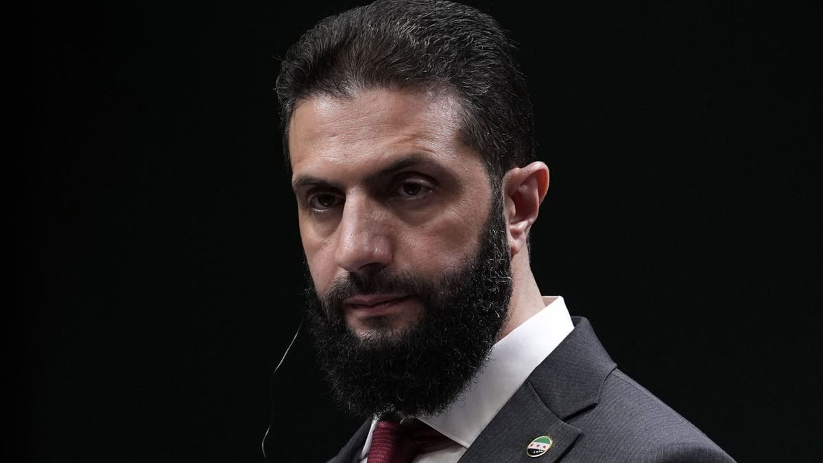 Ahmad al-Sharaa looks on during press conference