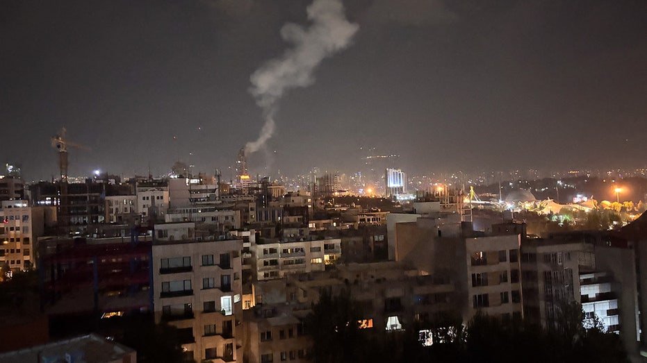 Aerial view of Tehran, Iran building with smoke rising from Israel's wave of strikes