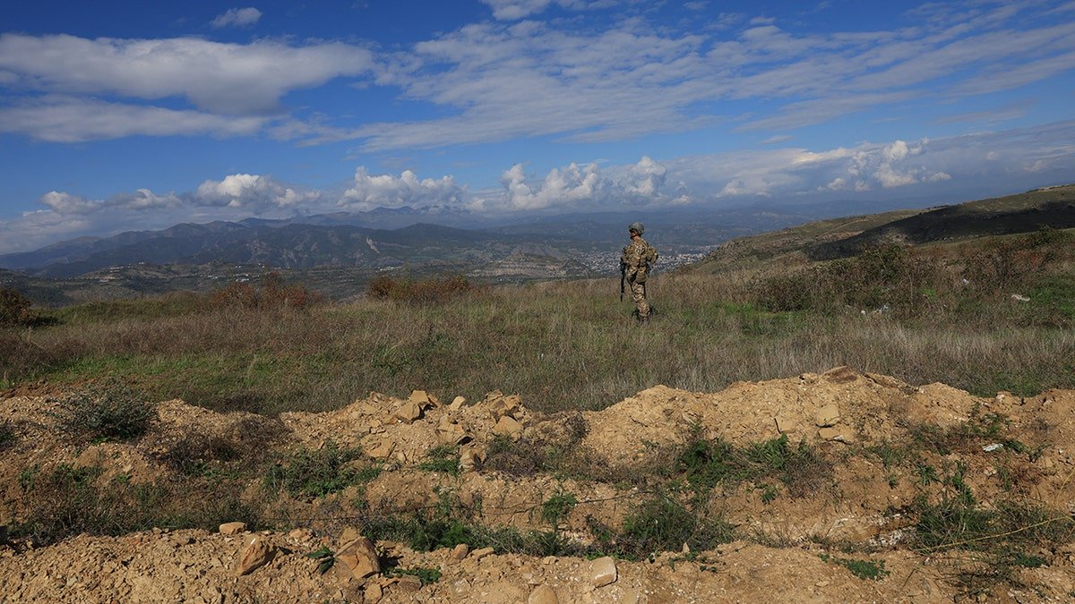 An Azeri serviceman stands near trenches at a former Armenian separatists military position in the village of Mukhtar (Muxtar) retaken recently by Azeri troops, during an Azeri government-organized media trip, in Azerbaijan's controlled region of Nagorno-Karabakh, on Oct. 3, 2023.