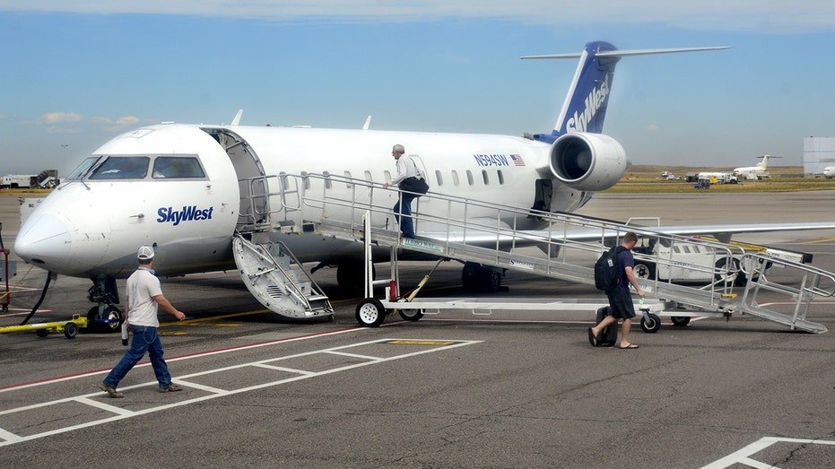 People walk to board a SkyWest Airlines jet
