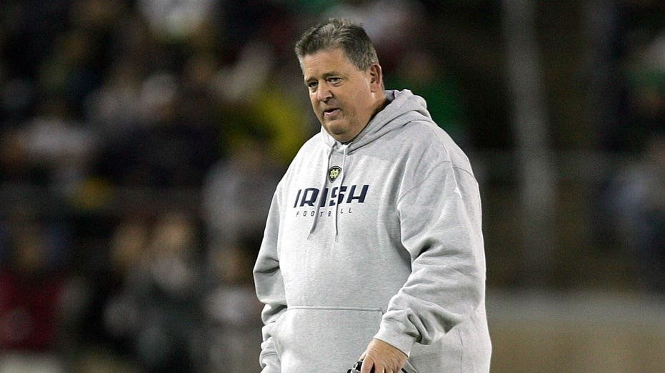 Charlie Weis looks on field
