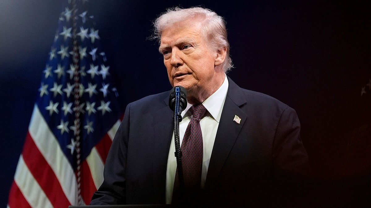 Donald Trump speaks in front of an American flag