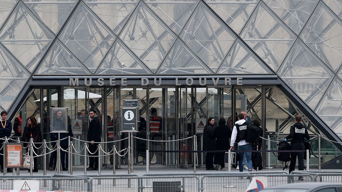 Forensic police officers arrive at the Louvre