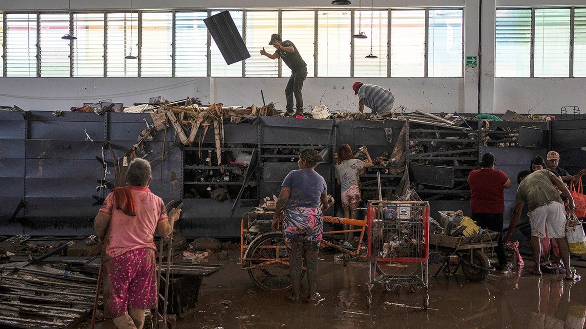 People looting items from the shelves of a supermarket