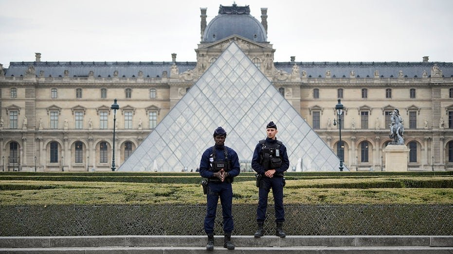 Police stand guard outside the Louvre museum at Louvre on October 19, 2025 in Paris, France.