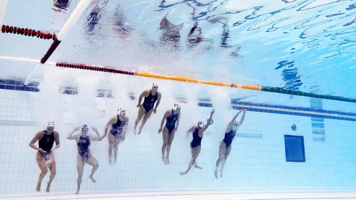 Members of Team United States jump into the pool prior to the Women's Water Polo Quarterfinal match between the United States and Japan on day nine of the Singapore 2025 World Aquatics Championships at OCBC Aquatic Centre on July 19, 2025, in Singapore.