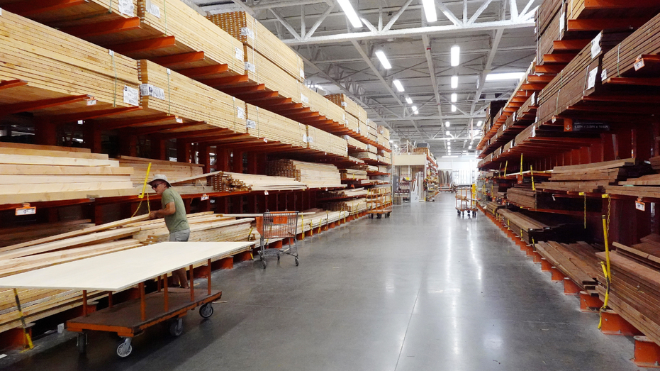 A customer shops in the lumber section of a Home Depot store.