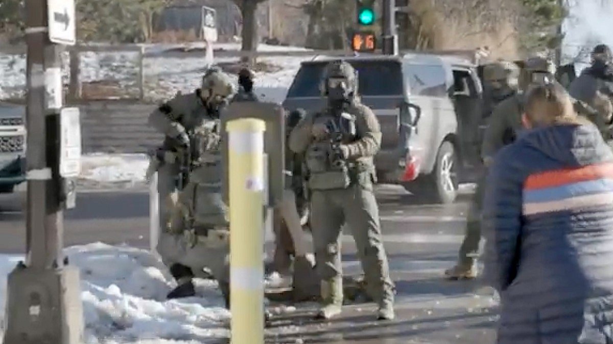 Federal agents tackling a man on the street.
