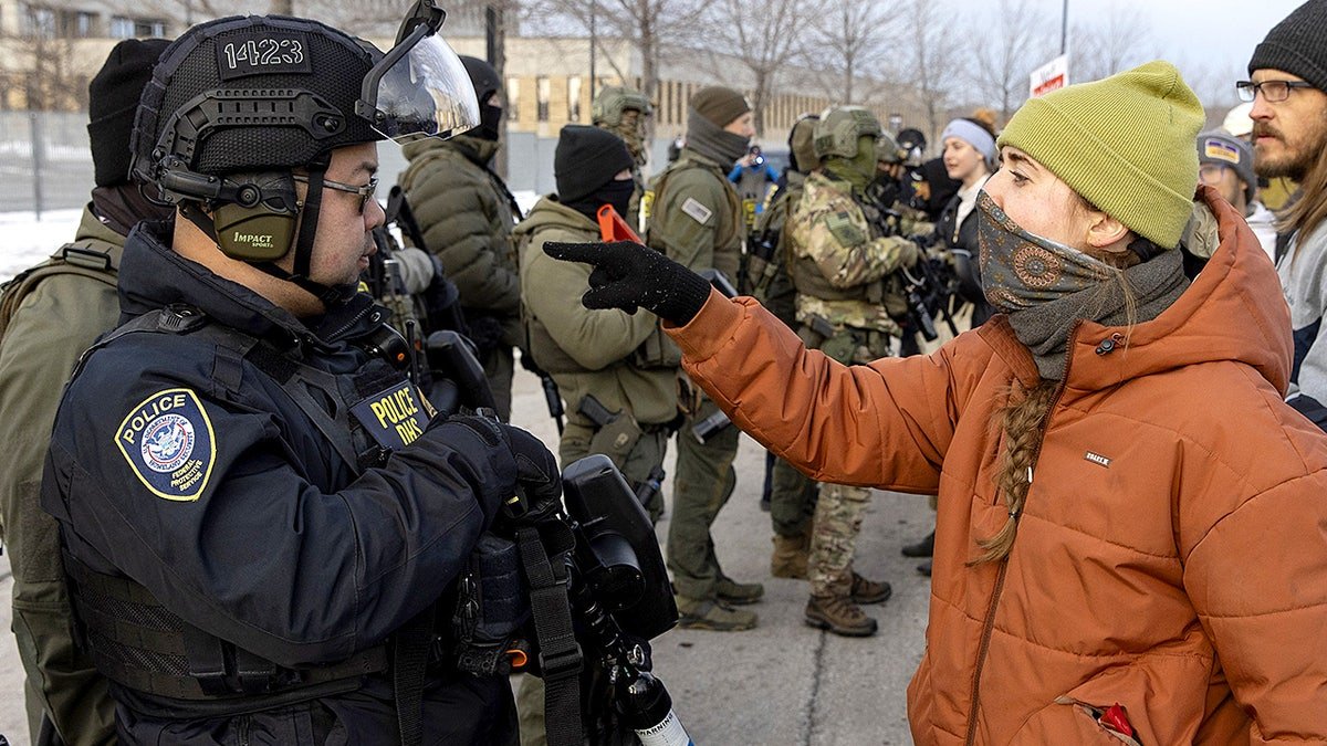 A protester confronts a Homeland Security officer during a demonstration outside a U.S. Immigration and Customs Enforcement facility amid heightened tensions in Minneapolis.