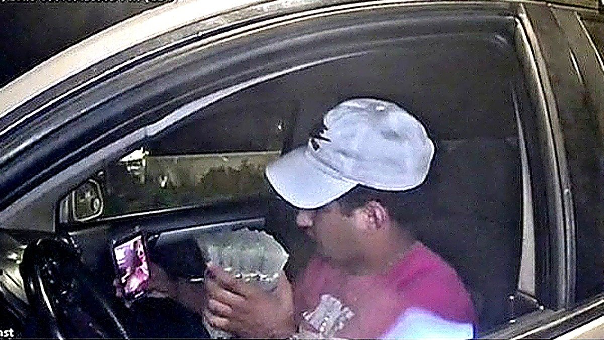 Suspect holds stacks of cash inside vehicle